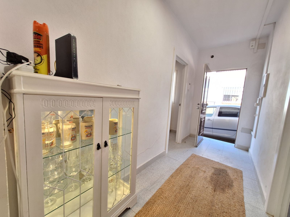 Hal met kast, uitzicht op auto door open deur.