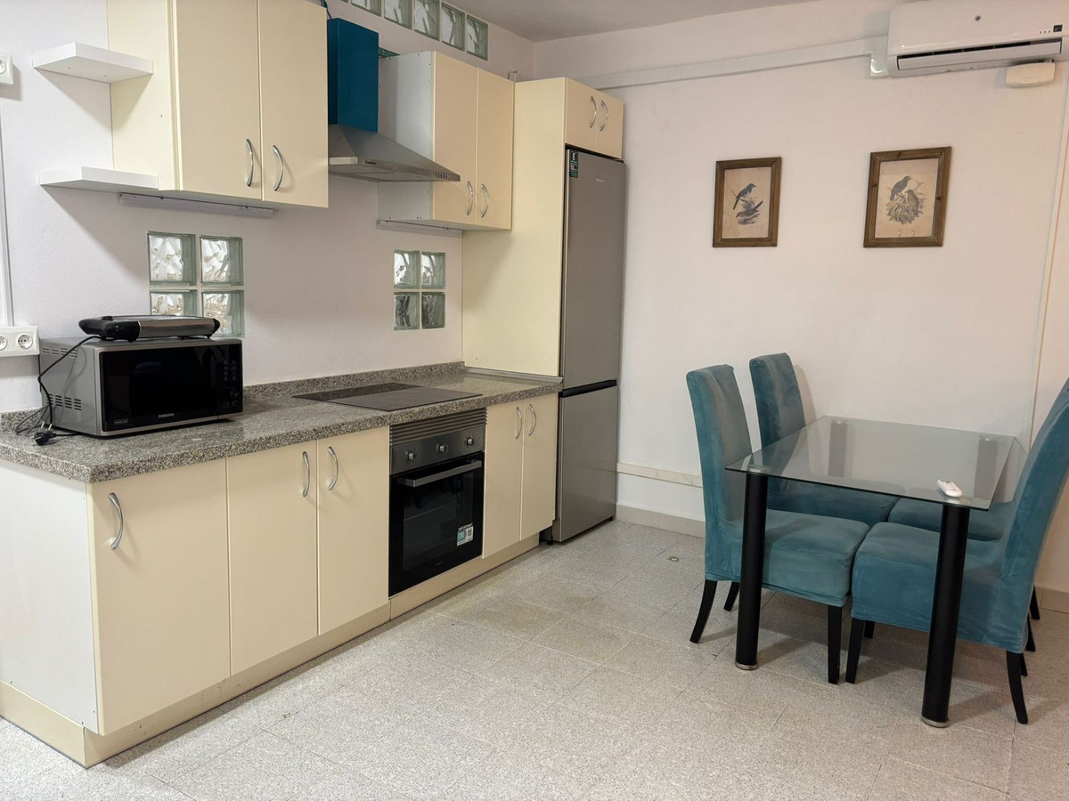 Compacte keuken met eethoek en blauwe stoelen