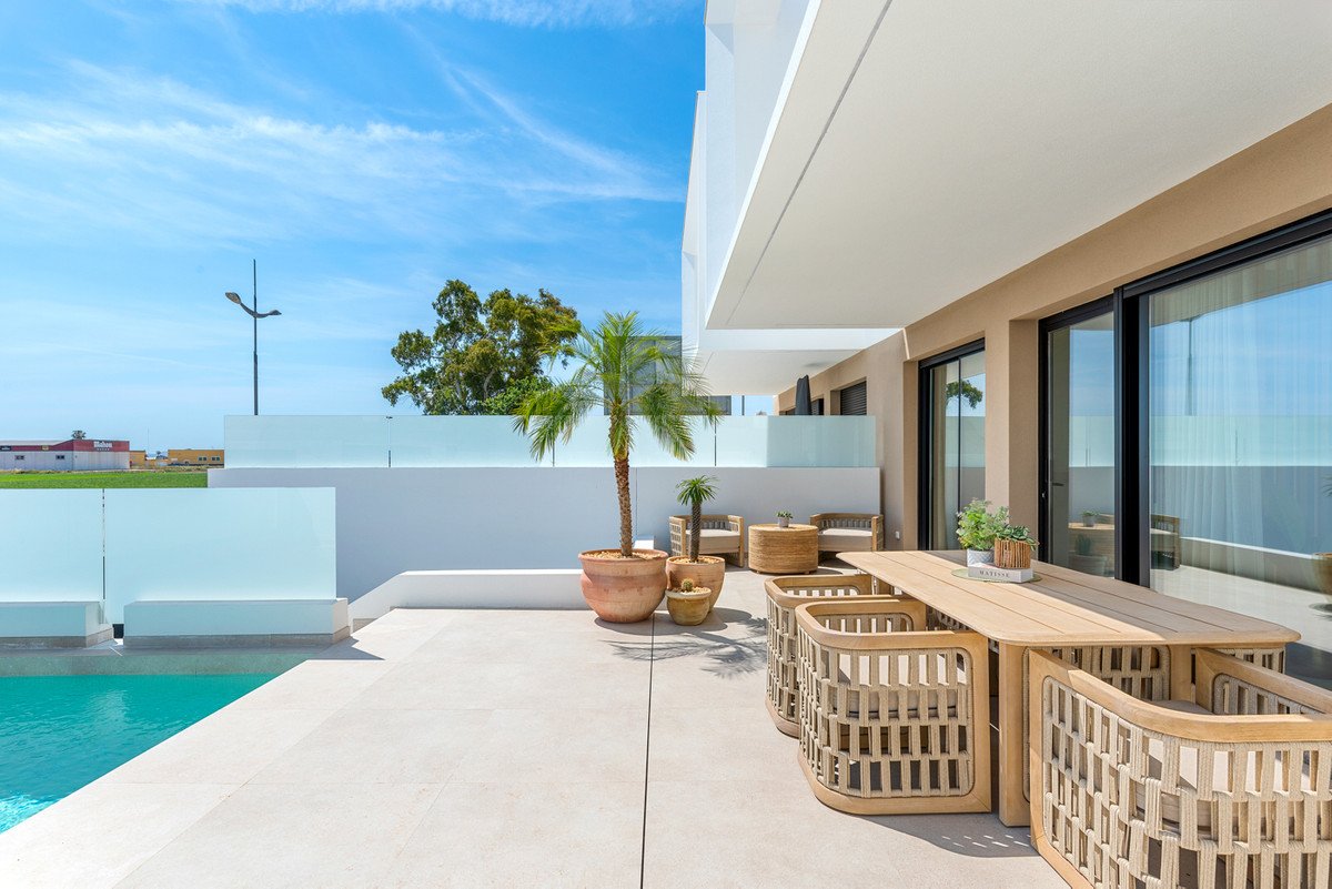 Modern patio with a dining table, chairs, and a pool. Features a palm tree and outdoor seating area.