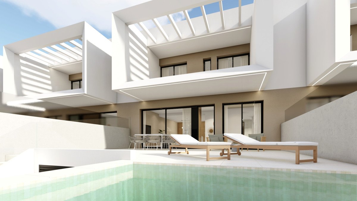 Modern villa exterior with a swimming pool, sun loungers, and a patio with outdoor dining furniture.