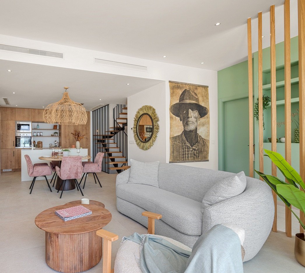 Modern living and dining area with open kitchen, comfortable sofa, and decorative elements.