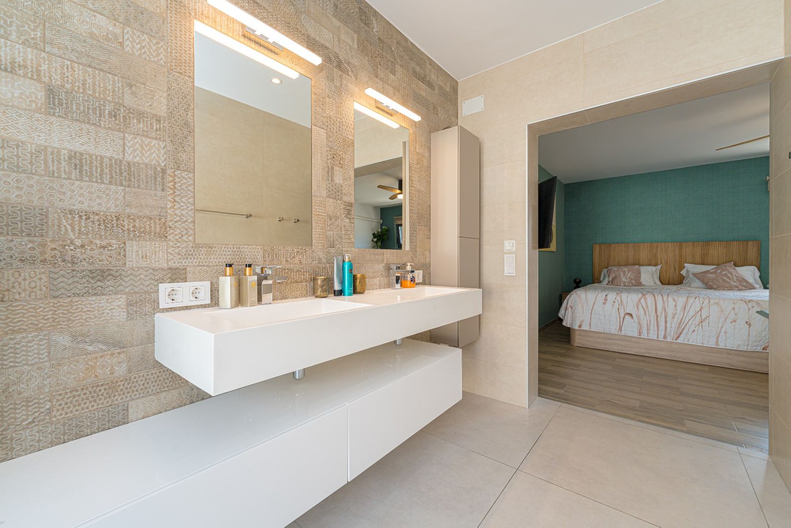 Moderne badkamer met dubbele wastafel en doorgang naar slaapkamer.