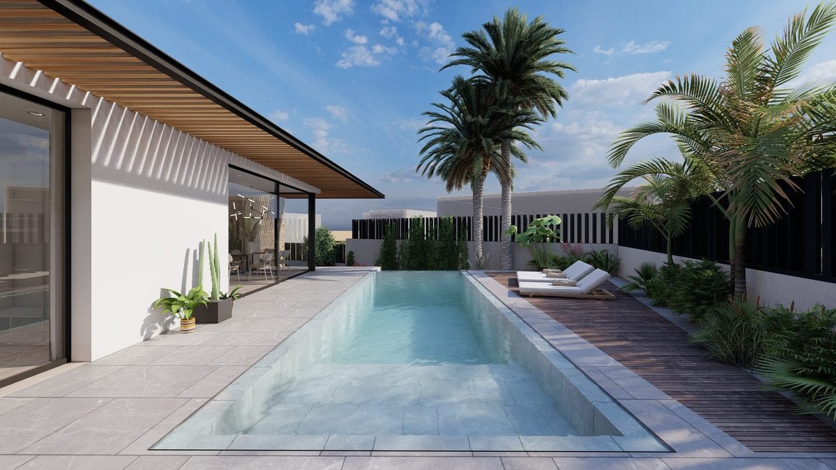 A modern property featuring a rectangular swimming pool, a wooden deck with lounge chairs, and palm trees under a blue sky.