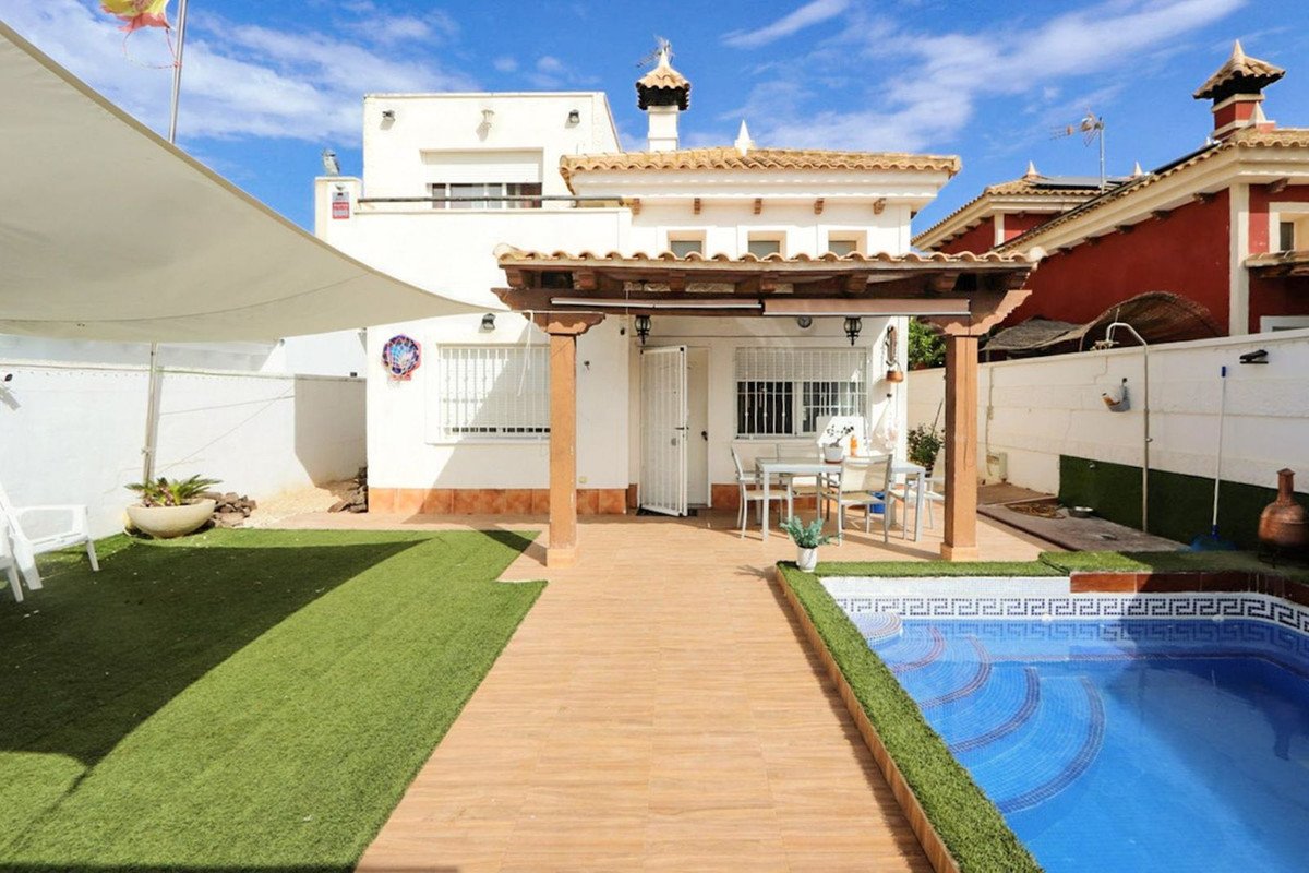 Luxurious swimming pool with garden and patio area under a pergola