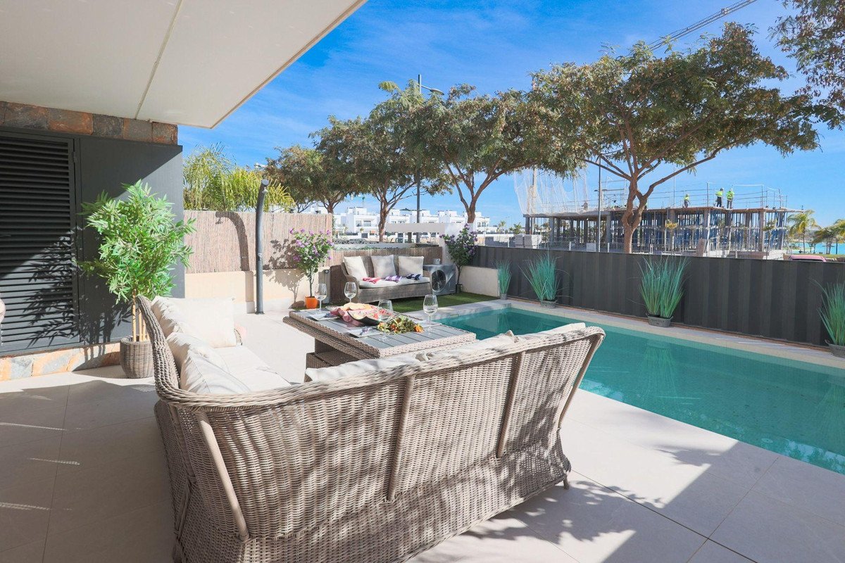 Outdoor terrace with wicker seating, a small pool, and tables, perfect for relaxation and entertainment.