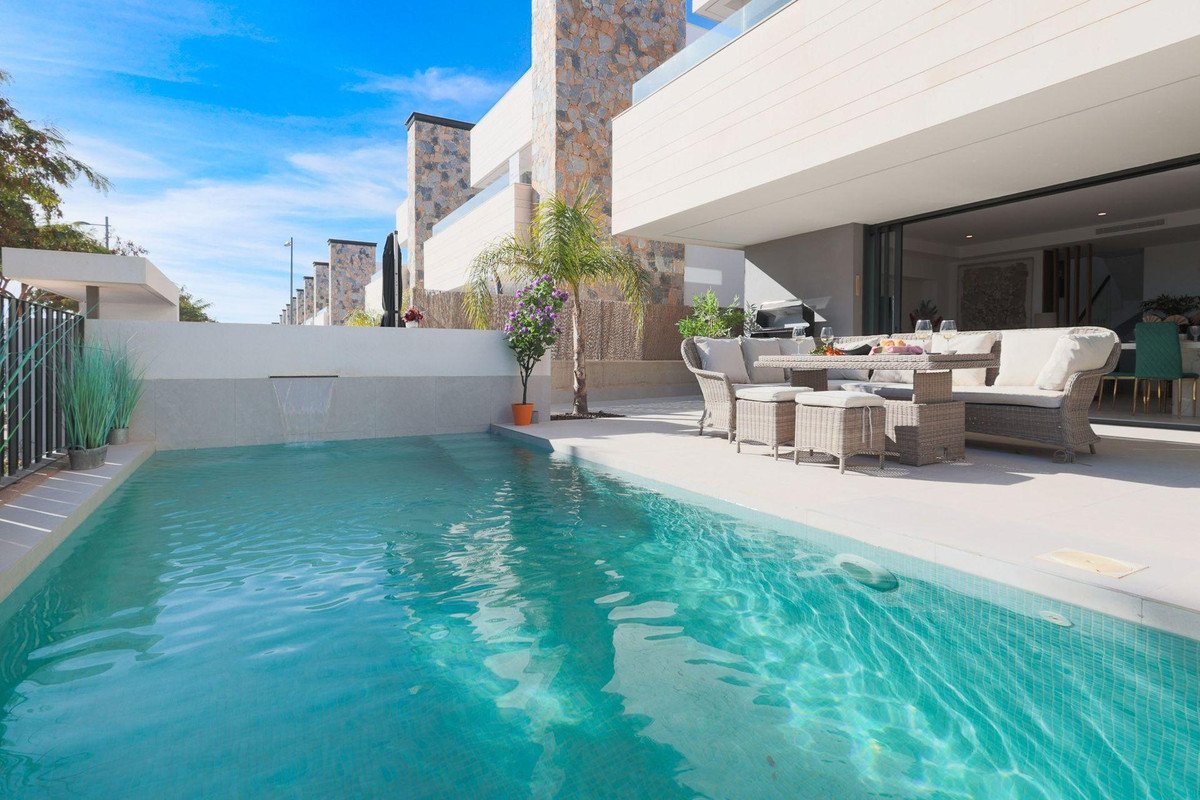 A private swimming pool and outdoor seating area with a dining table and chairs, perfect for relaxation and entertainment.