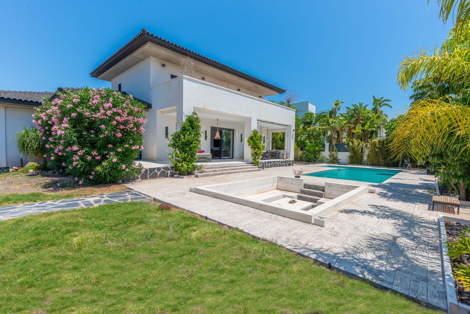 Moderne villa met zwembad en weelderige tuin.