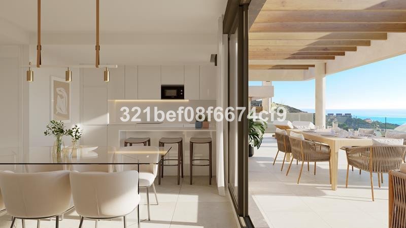 Modern kitchen and dining area opening to a spacious terrace with a beautiful sea view and outdoor dining furniture.