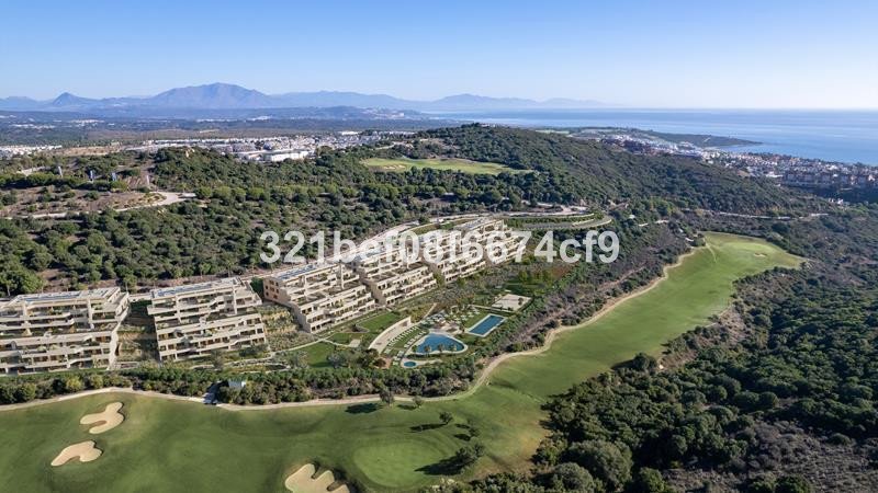 Modern apartments overlooking a lush golf course and the sparkling sea, set against a backdrop of rolling hills and mountains.
