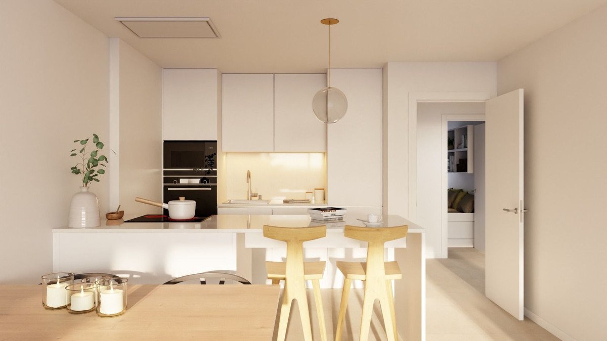 A modern white kitchen with an island, pendant light, built-in oven, and seating for two at the island.
