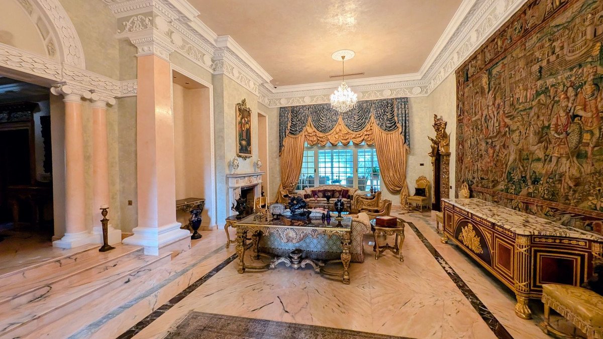 Luxury living room with ornate tapestry, fireplace, and marble flooring.