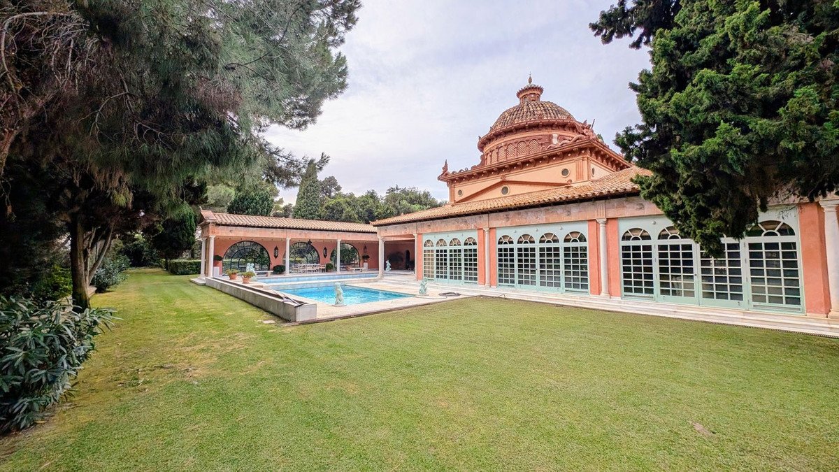 Villa with pool, large lawn, and domed architecture surrounded by trees