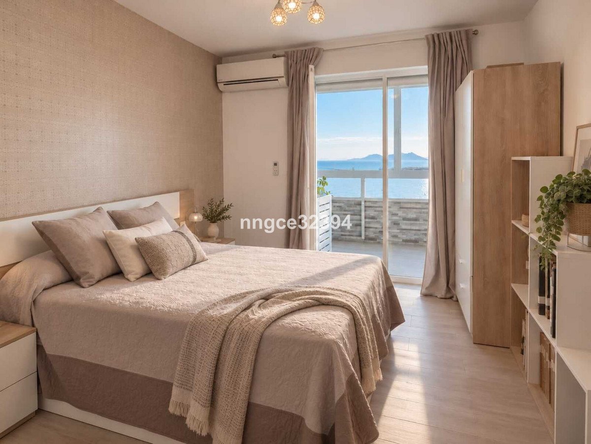 Bedroom with a large bed, air conditioning, and sliding doors leading to a balcony with a sea view.