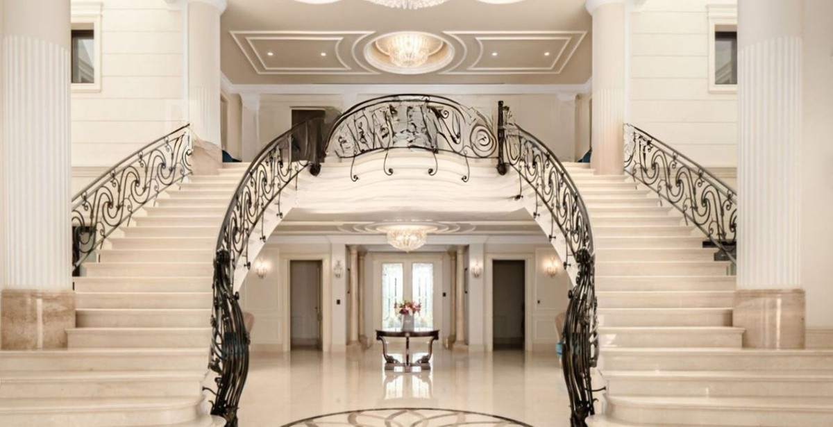 Majestueuze entree met trap in een luxe woning.