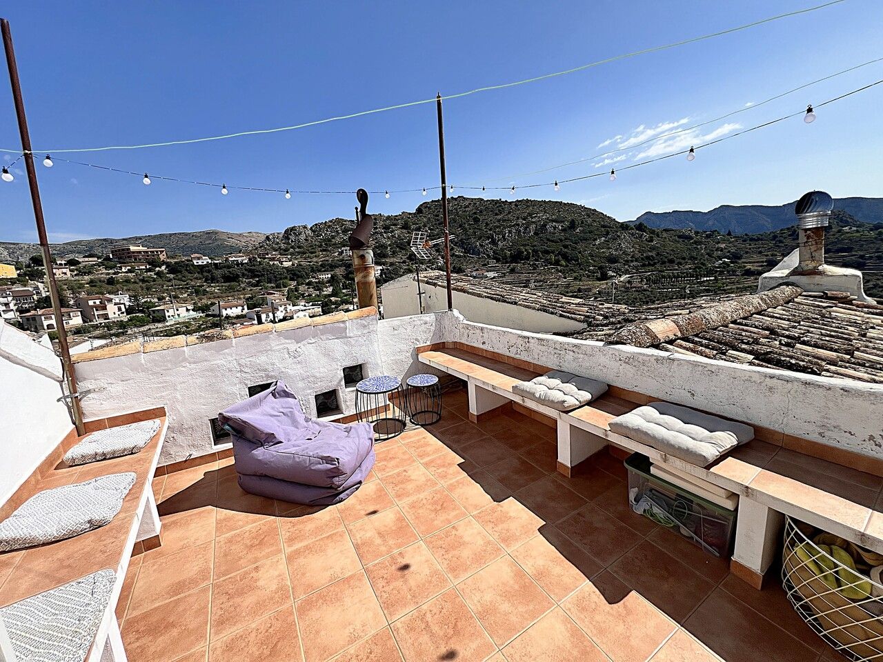 Buitenterras met uitzicht op de bergen en een paarse zitzak