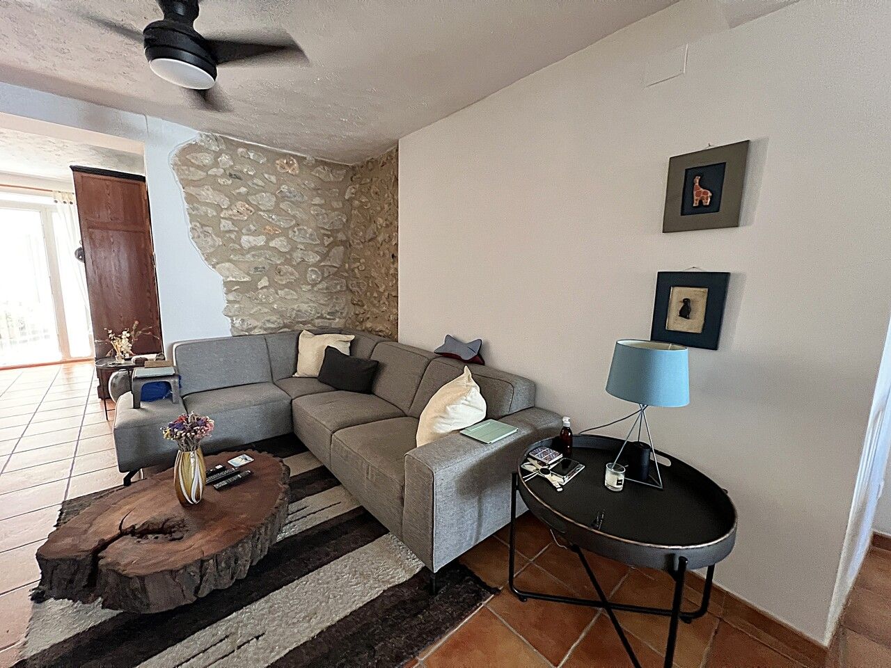 Gezellige woonkamer interieur met grijze hoekbank en houten tafel.