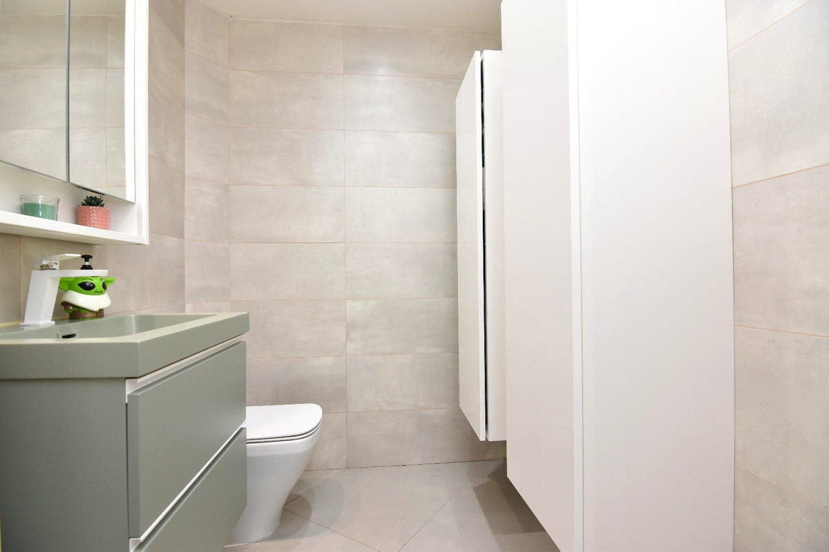 Moderne badkamer met olijfgroene kast en witte accenten.