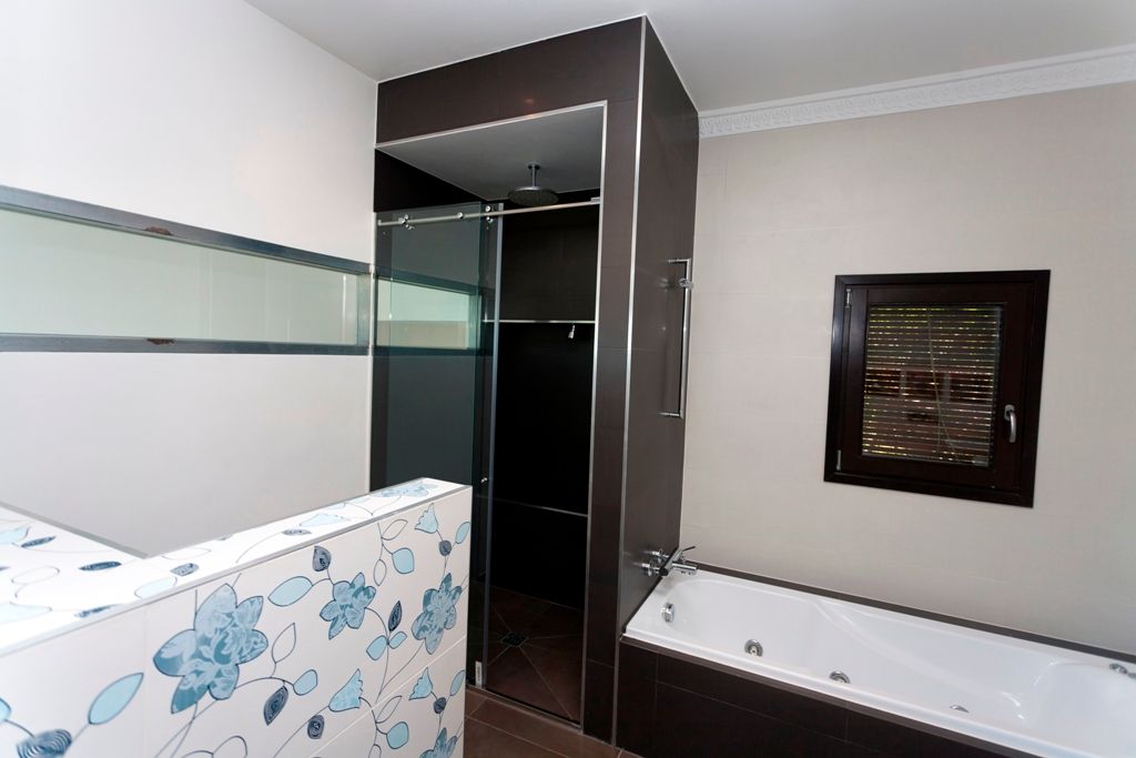 Moderne badkamer met inloopdouche en ligbad.