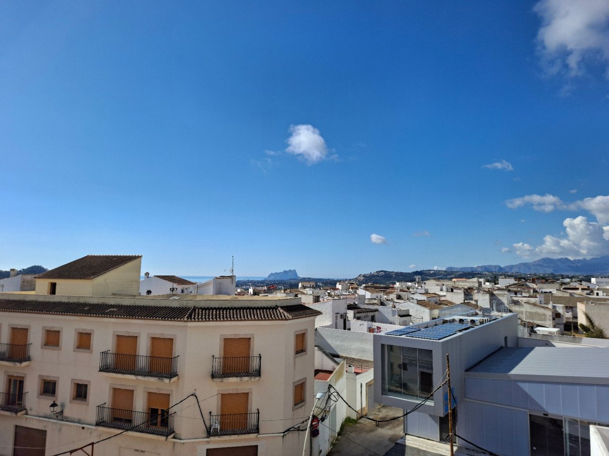 Rooftop view of a Mediterranean town with white buildings and blue sky