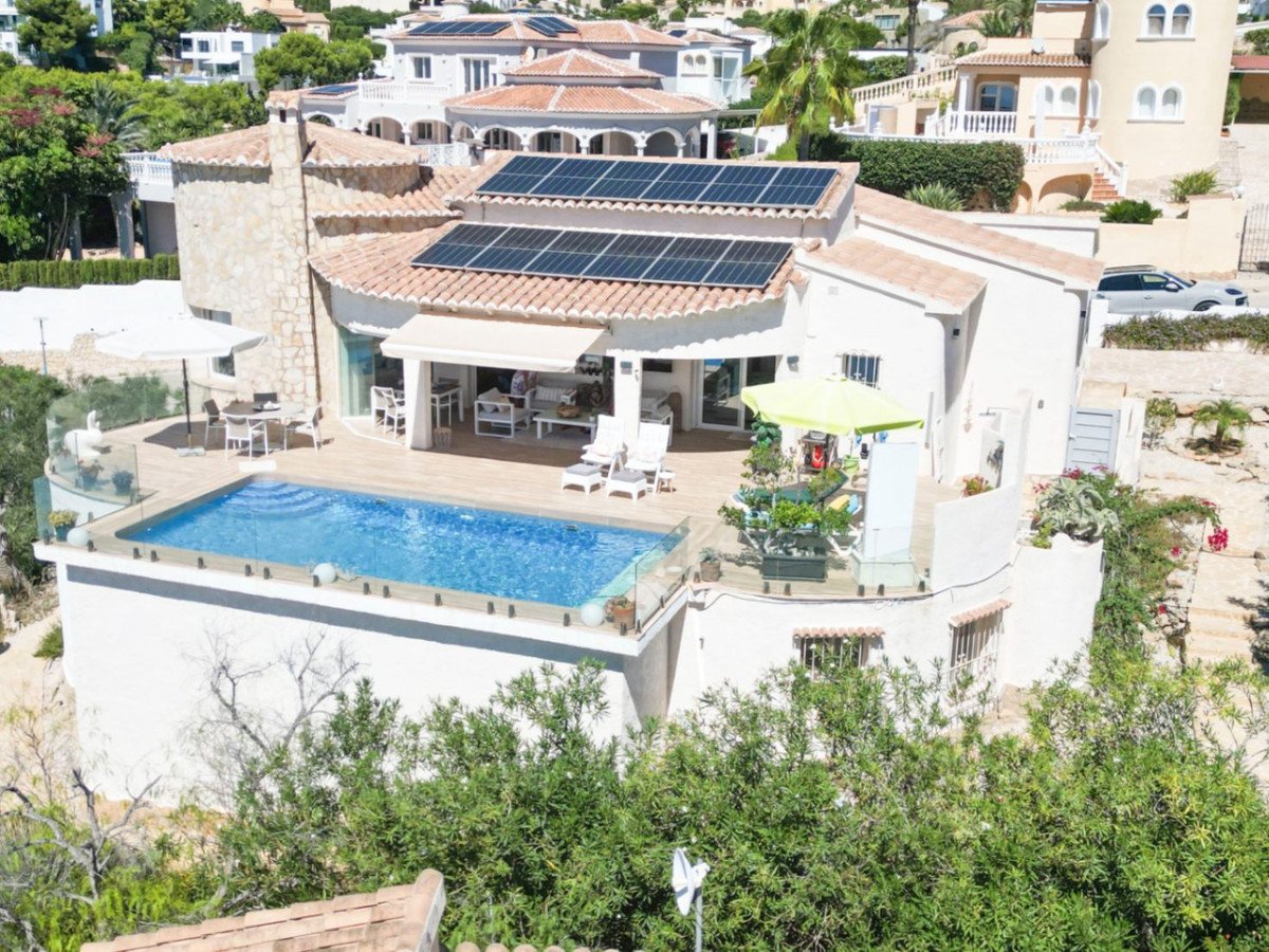 Luxury villa with a private swimming pool, solar panels on the roof, and outdoor seating areas overlooking a residential area.