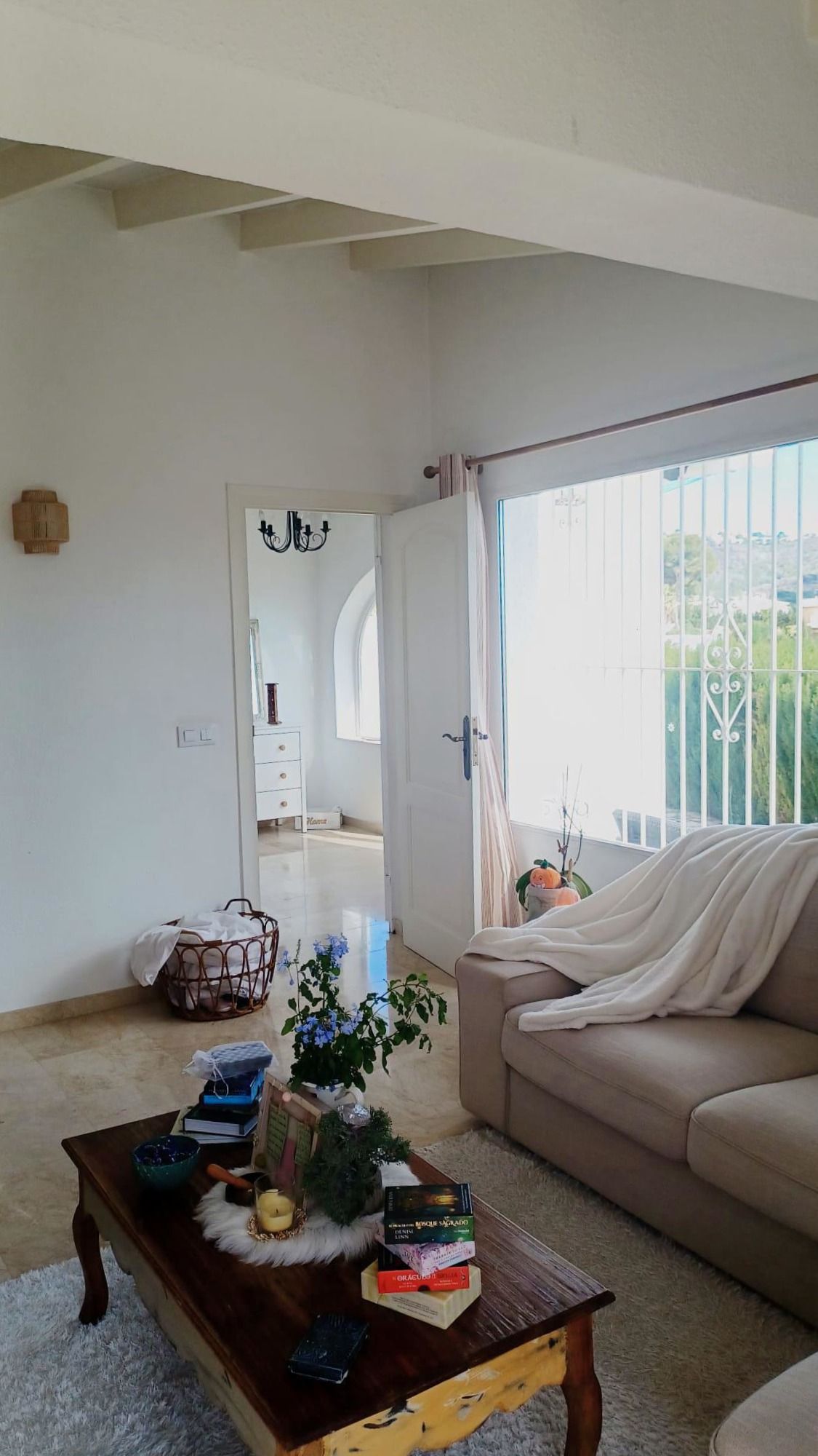 Lichte woonkamer interieur met een open deur en een uitzicht naar buiten.