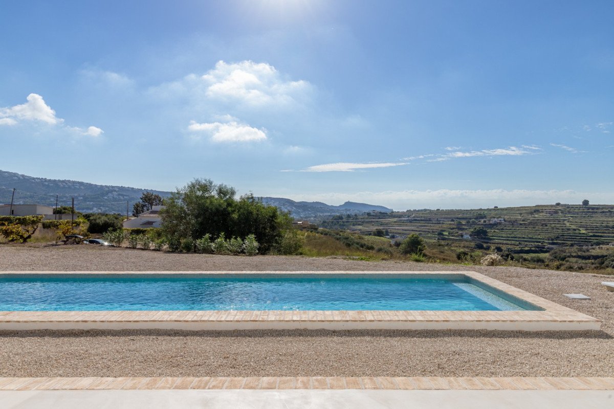 Outdoor swimming pool with clear blue water and panoramic countryside view