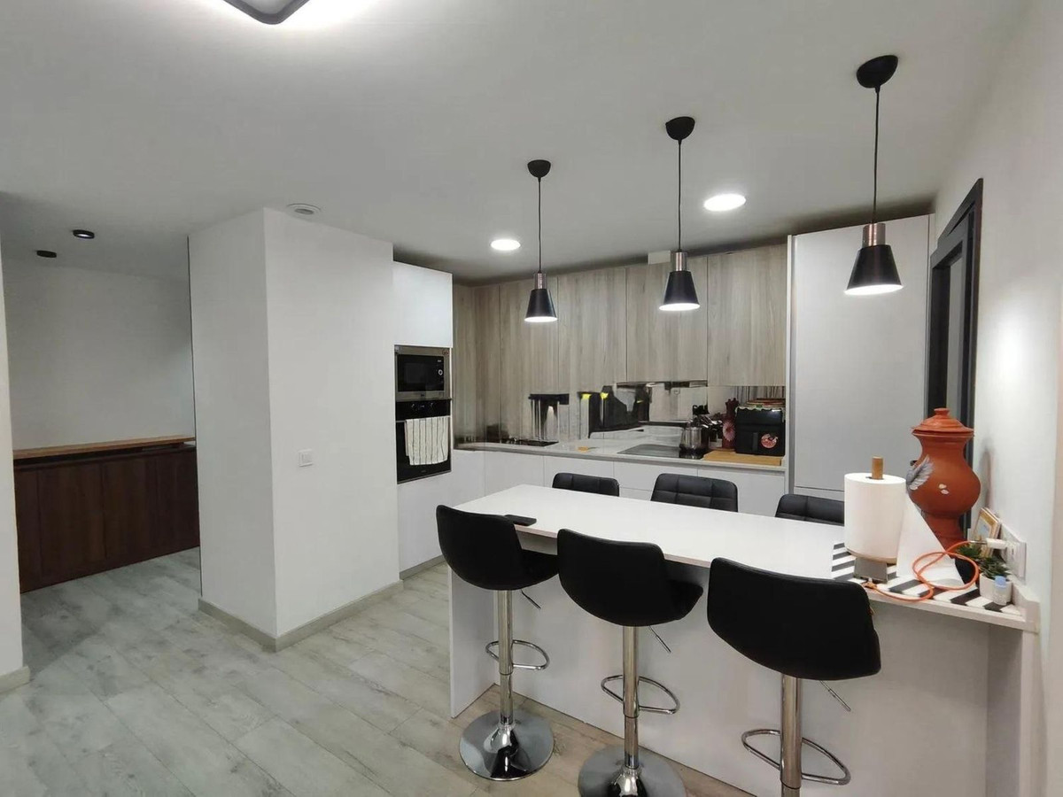 Moderne keuken met bar en krukken.