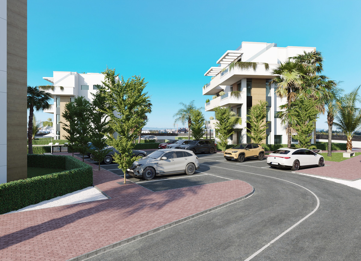 Moderne appartementencomplex met parkeerplaats voor auto's en groene beplanting.