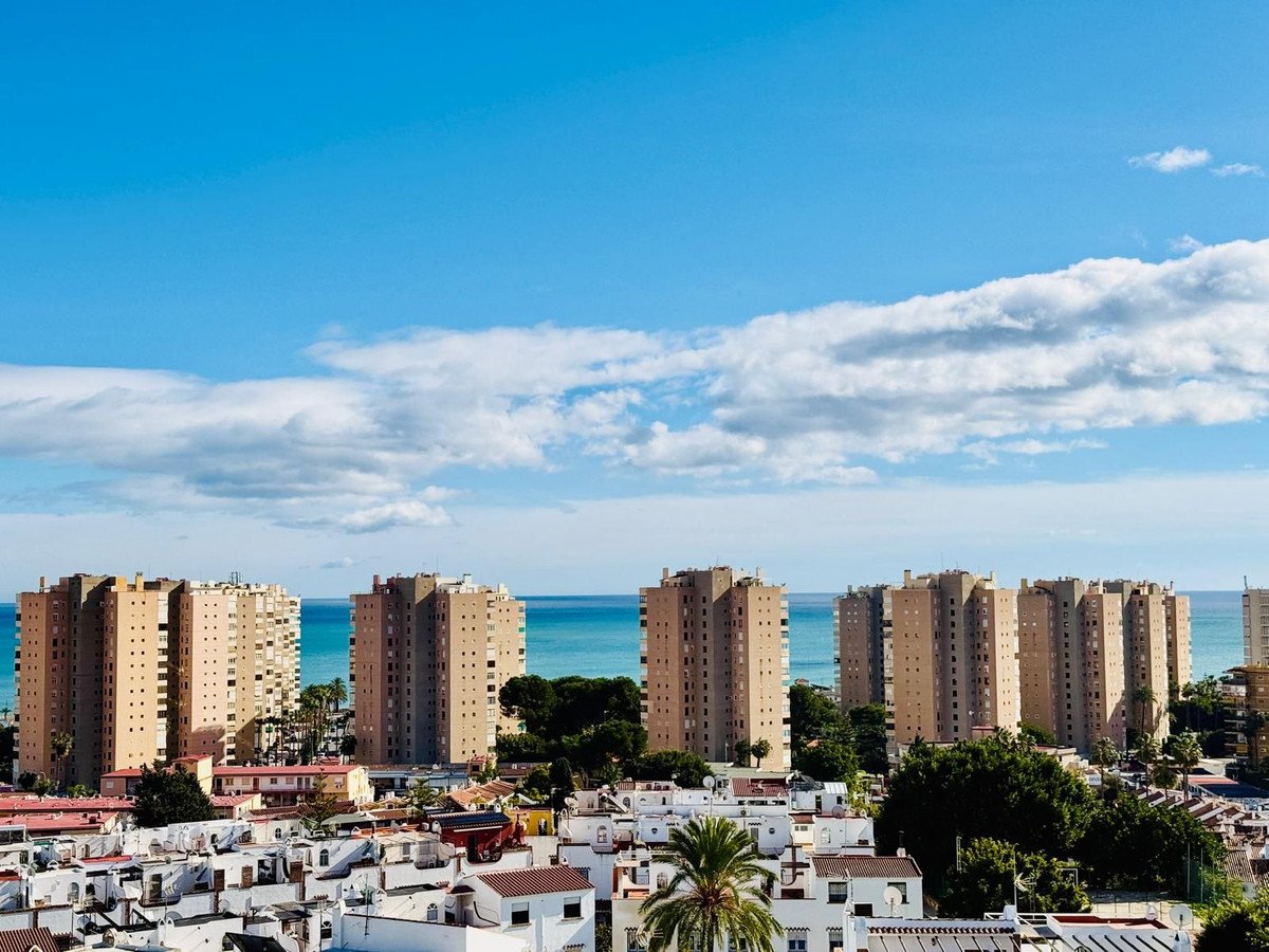 Cityscape with high-rise buildings and ocean view under a blue sky
