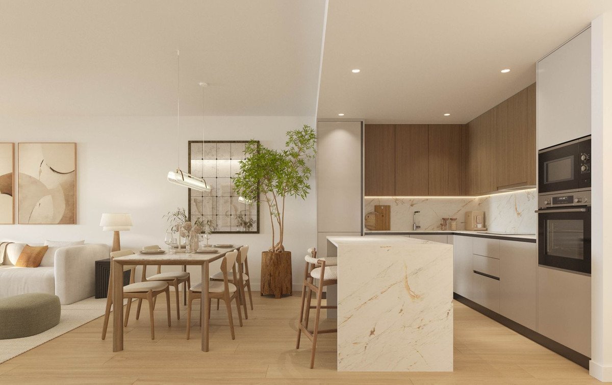 Modern open-plan kitchen and dining area with marble island, wooden cabinets, and light wood flooring.