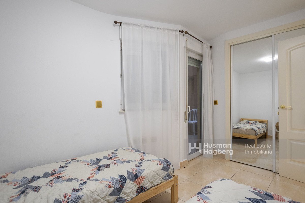 Bedroom with two beds, balcony access, and mirrored closet doors.