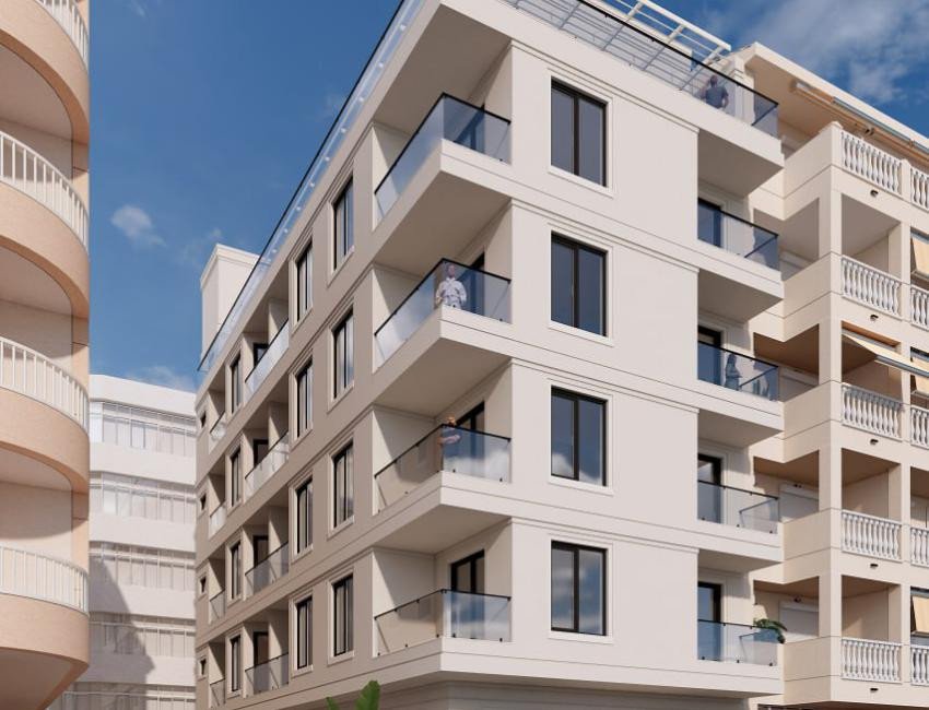 Modern apartment building with balconies featuring glass railings and city views under a clear blue sky.