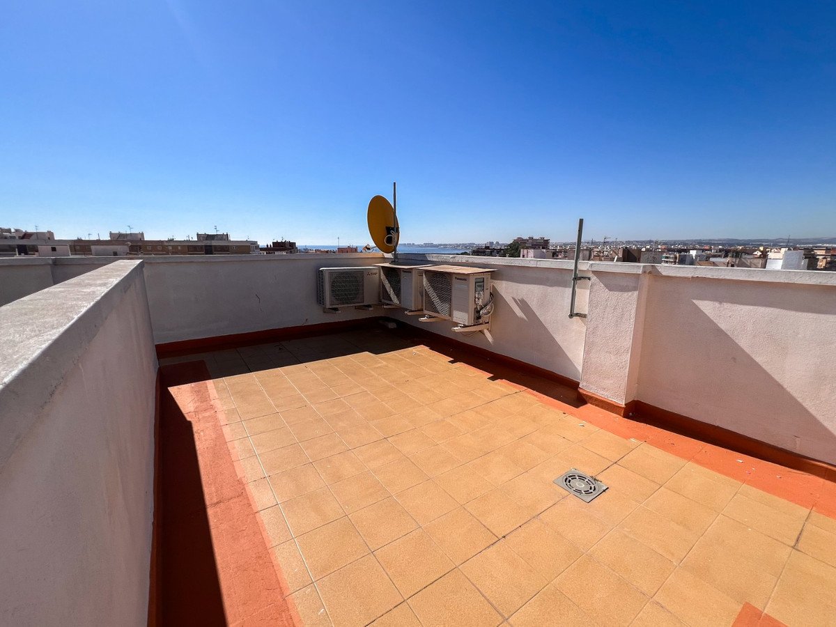 Spacious tiled terrace with city and sea views, featuring air conditioning units and a satellite dish on a clear day.