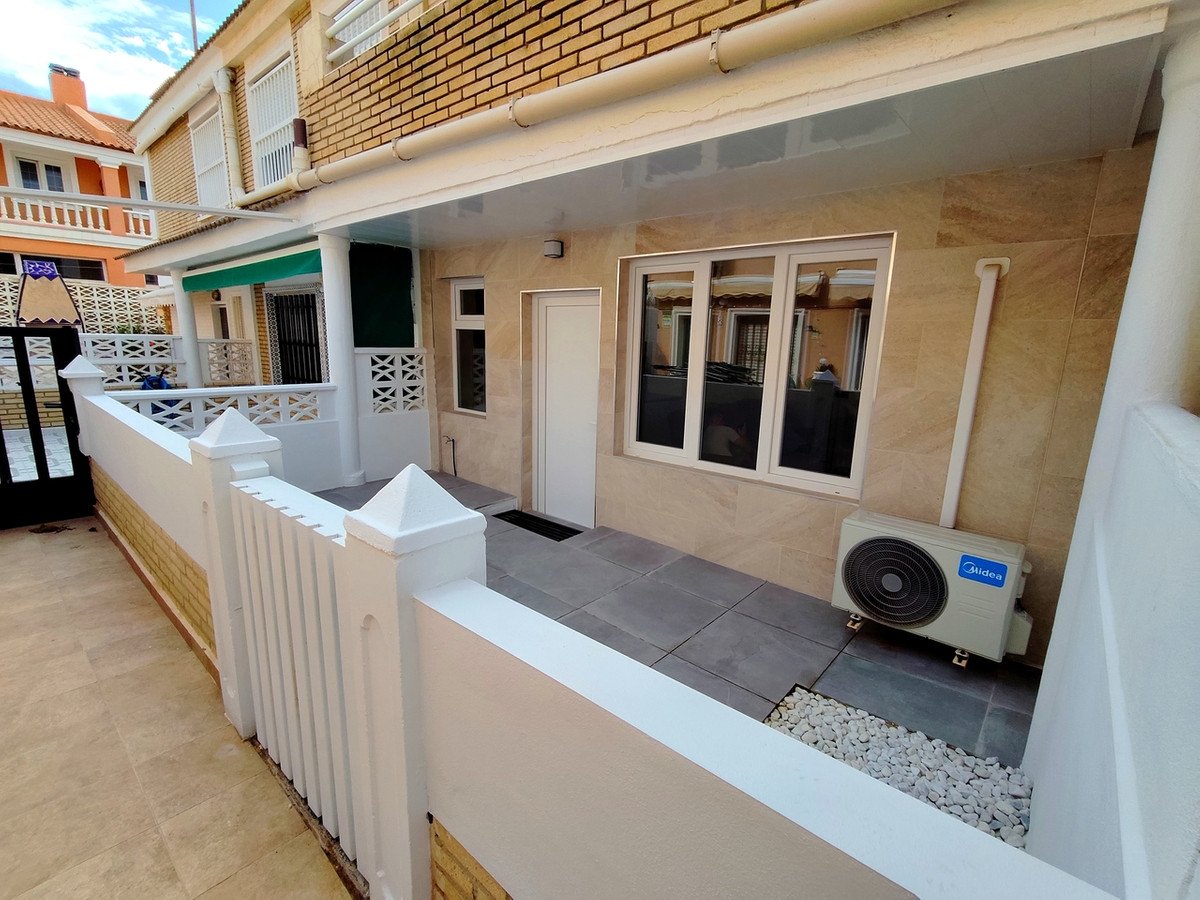 Terrace view with an air conditioning unit next to a window and a white fence.