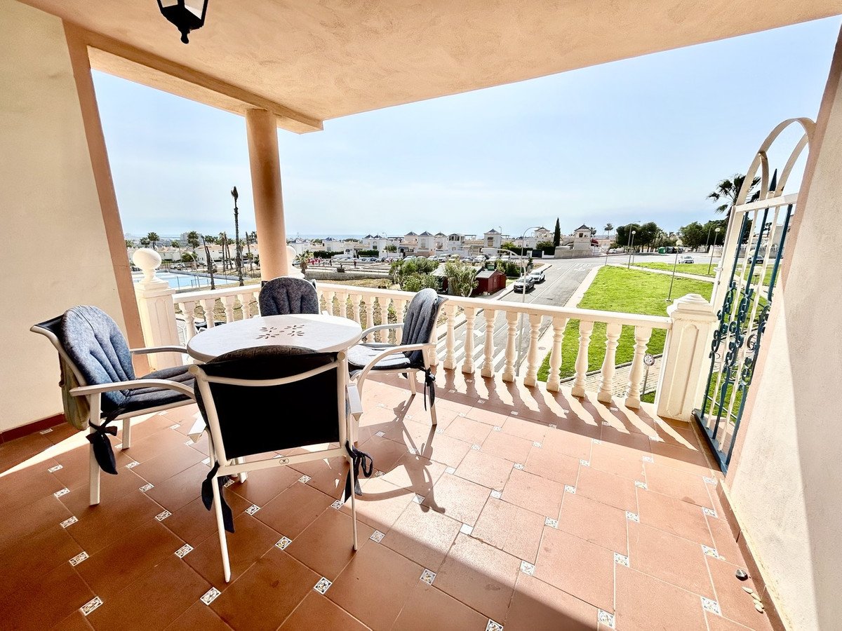 Balcony with table and chairs overlooking the sea and town