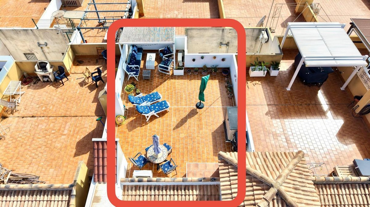 Spacious tiled terrace with lounge chairs, sunbeds, outdoor dining set, and plants. Overhead view of an apartment's private outdoor space.
