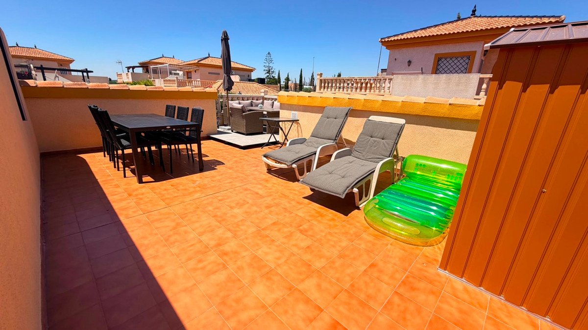 Rooftop terrace with dining set, lounge chairs, and inflatable pool