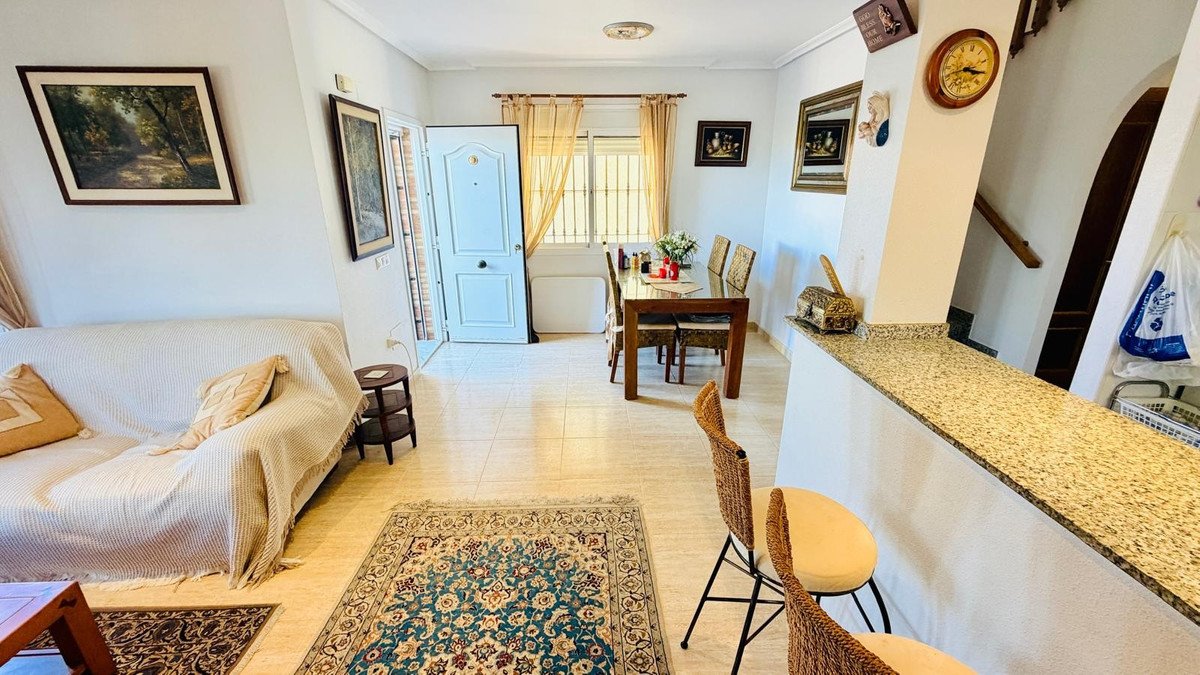 Living and dining room with open space, rug, sofa, and dining table