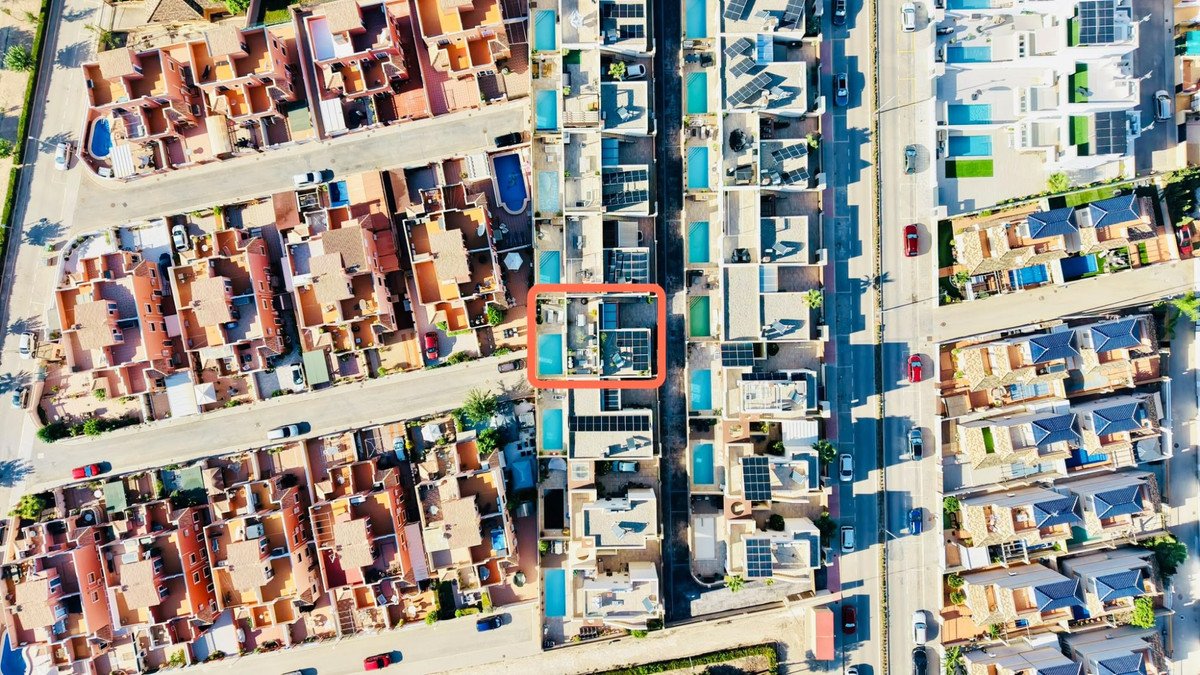 Aerial view of a property featuring a private pool, terrace, and rooftop solar panels.