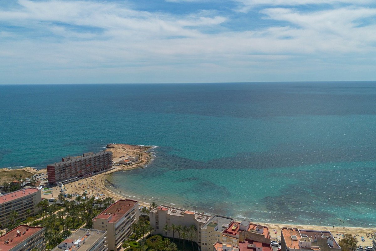 Aerial view of coastal apartments with sea and beach in the foreground