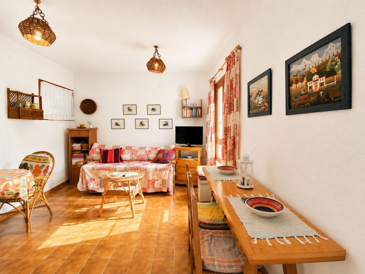 Bright living room with sofa, dining table, and colorful decor
