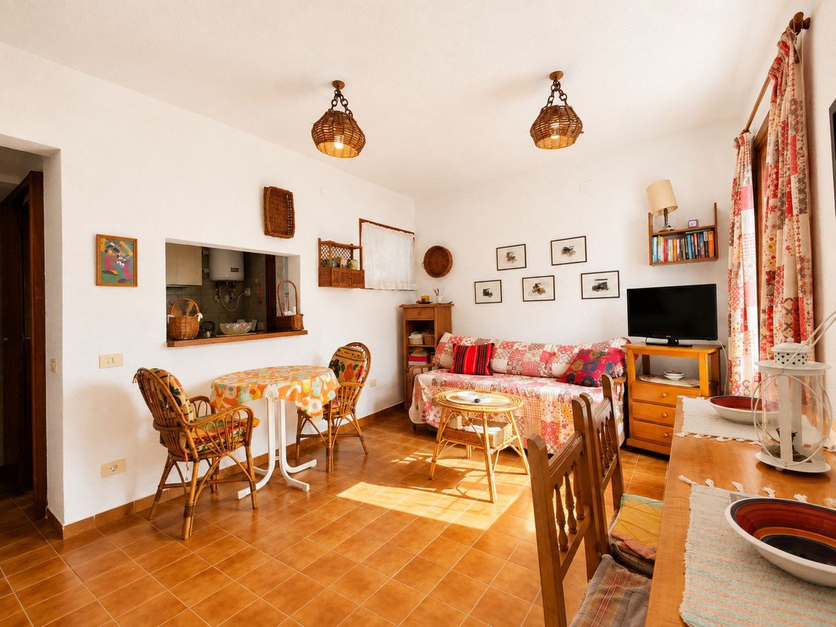 A bright living room with a dining area, sofa, and wicker chairs