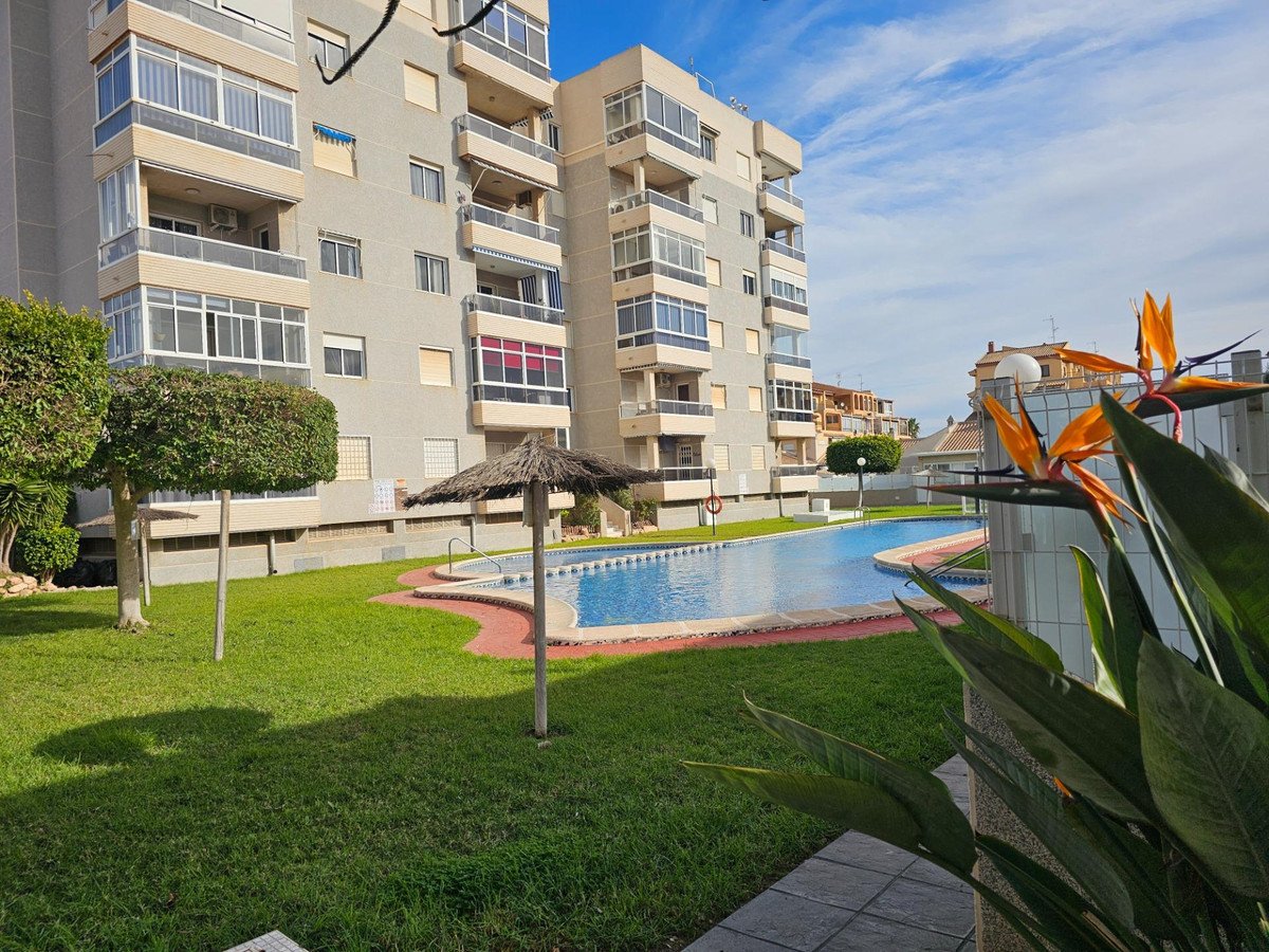 Modern apartment complex with swimming pool and well-maintained garden