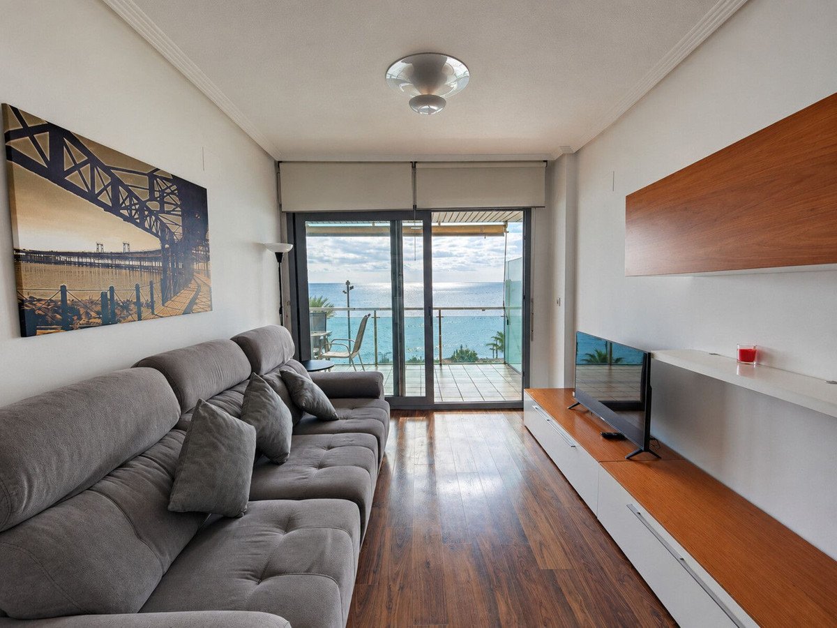 Modern living room with gray sofa, sea view through sliding glass doors