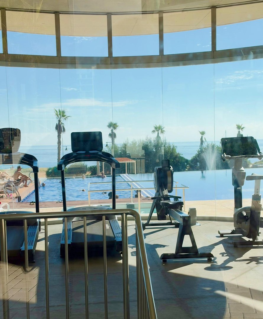 Gym with ocean view, pool, and exercise equipment