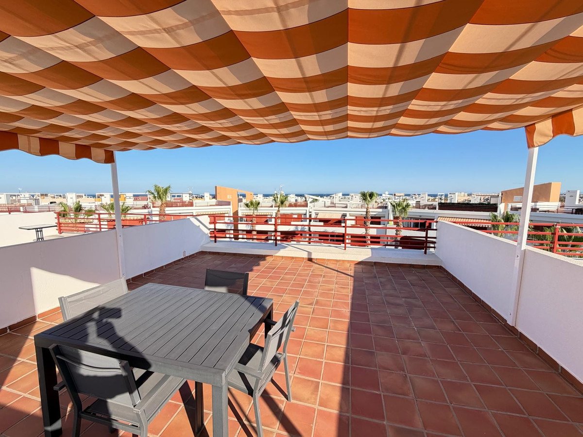 Rooftop terrace with shaded seating and sea view