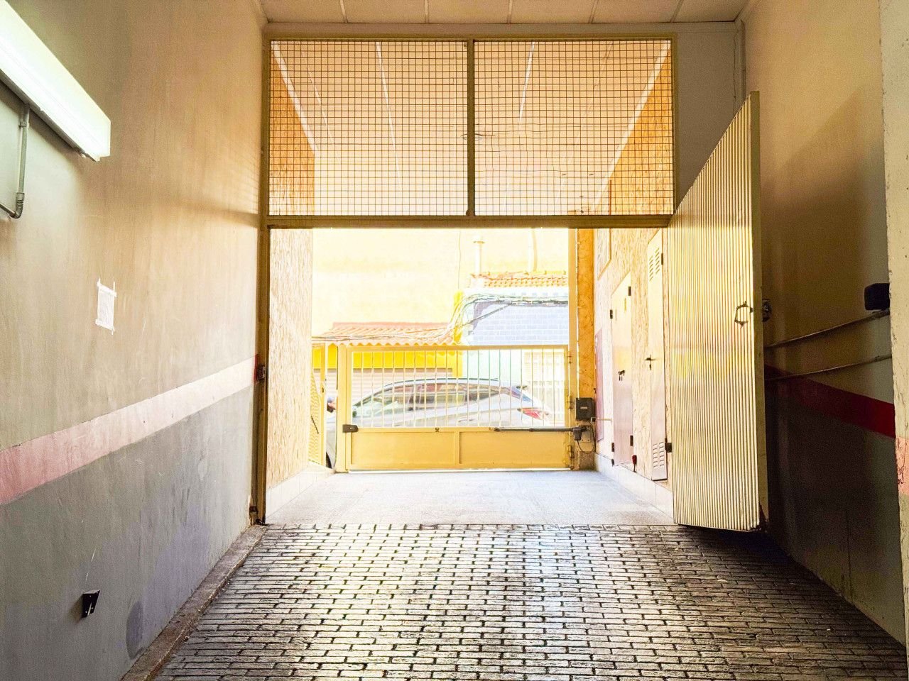 Indoor parking area with yellow gate and car view.
