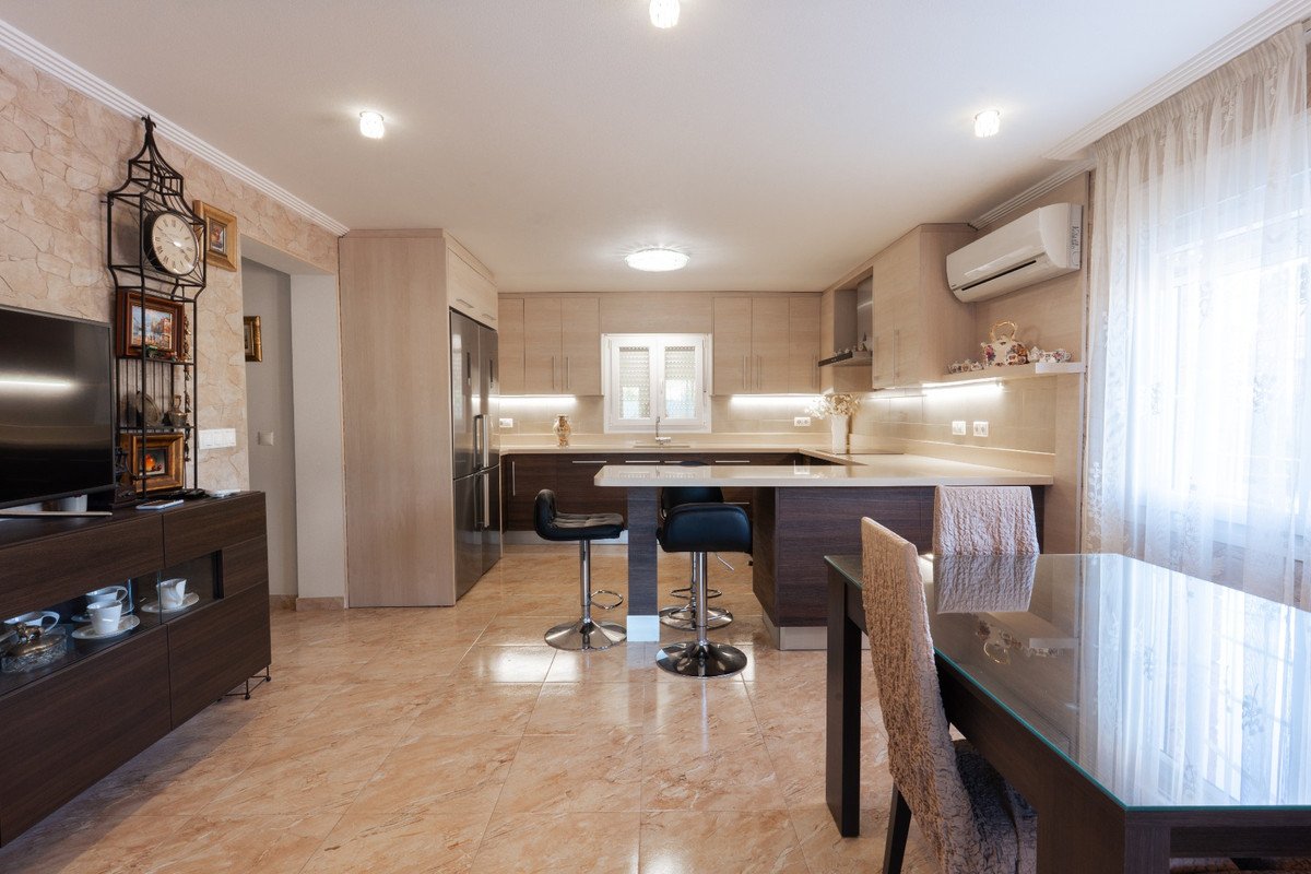 Open plan kitchen with living and dining area, modern cabinetry, and bar stools