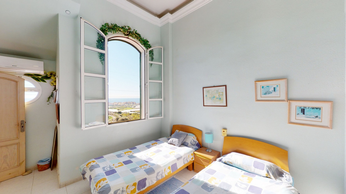 Slaapkamer met twee bedden en uitzicht op zee