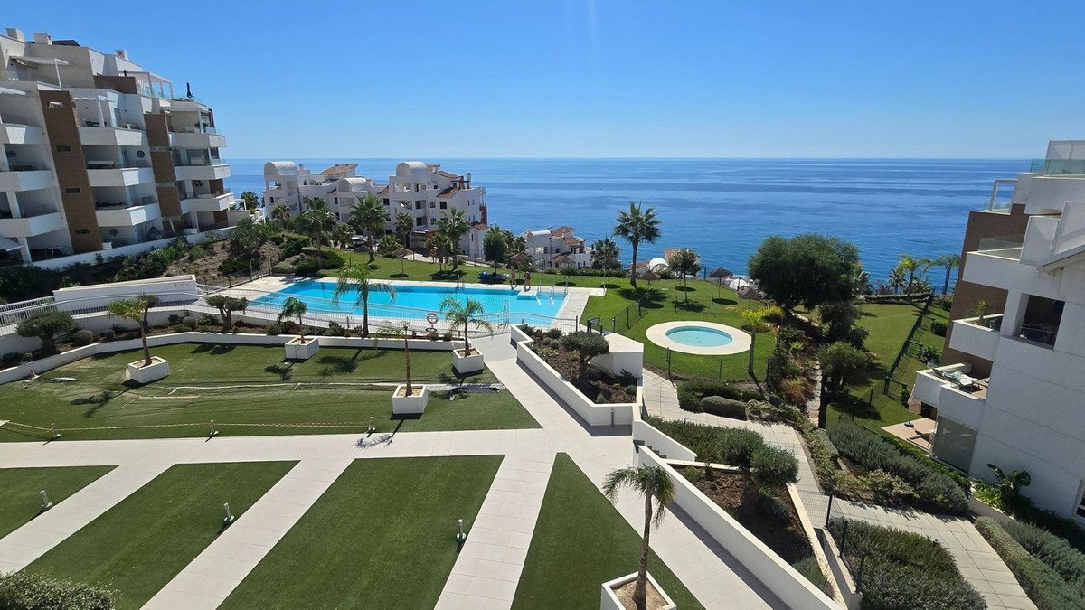 Apartment complex with sea view, swimming pool, and landscaped gardens